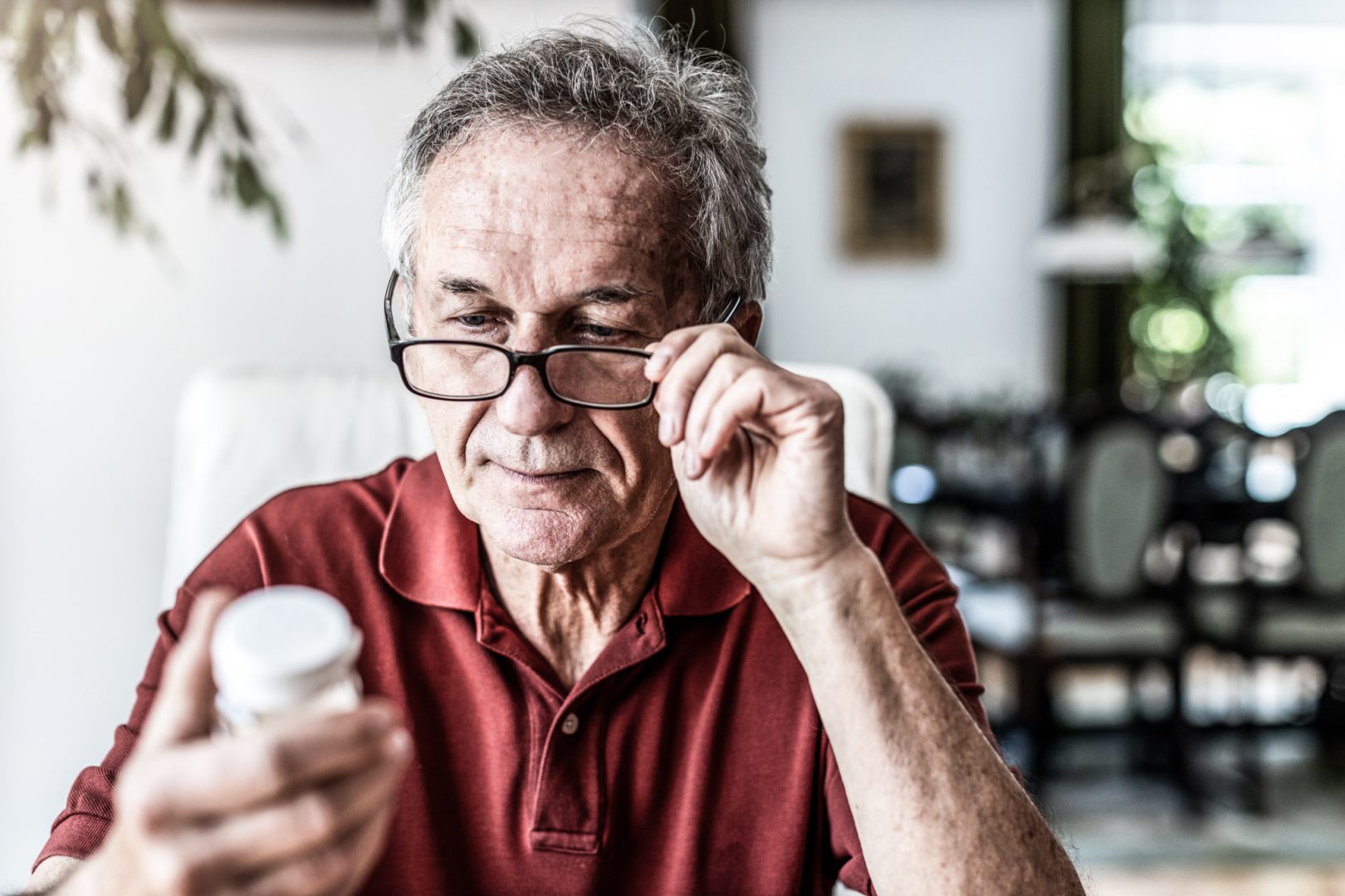 Senior man taking prescription medicine at home